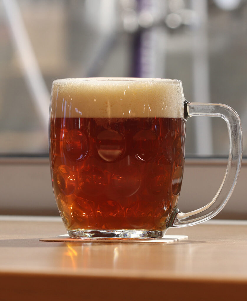Amber Märzen lager in a clear glass stein with a creamy foam head.